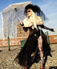 Renée Nicole Gray as Lady Gaga Renée Nicole Gray as a Lady Gaga impersonator on a Brooklyn rooftop wearing a black skirt and top with a white fur sole and lace umbrella.